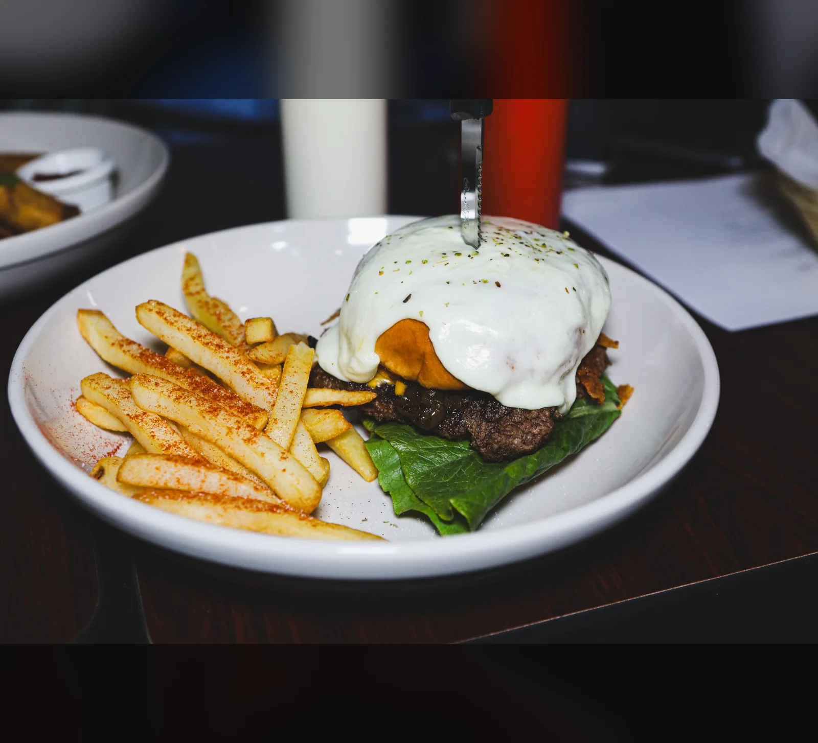 Mozzarella-topped burger with seasoned fries, photographed for a food brand