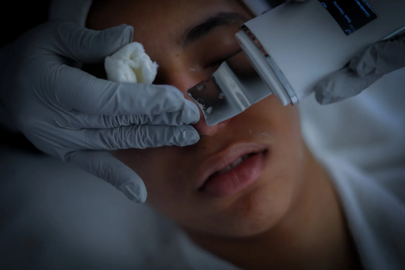 Close-up of a skincare treatment performed with gloved hands