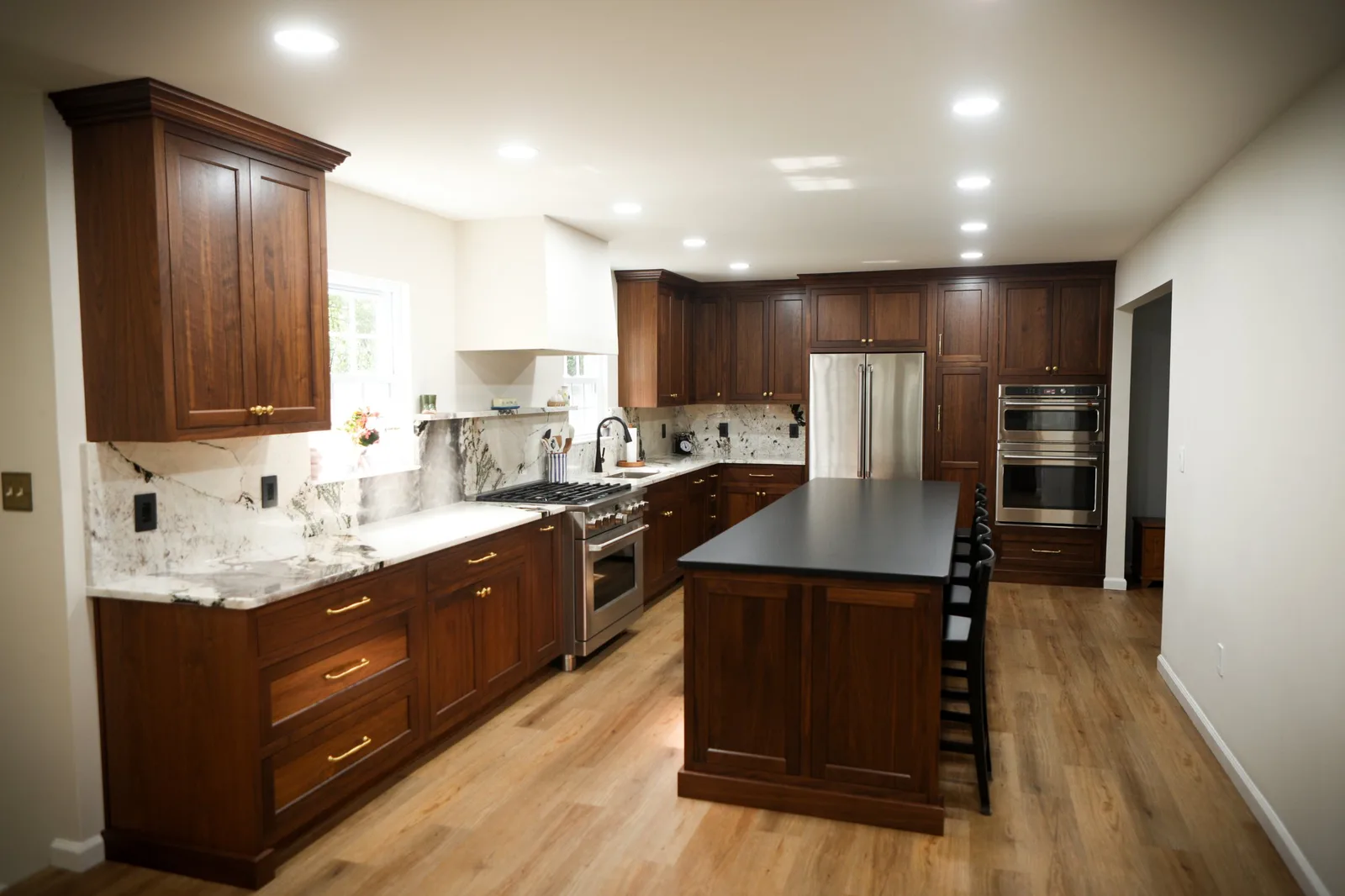 Renovated kitchen with walnut cabinetry and marble backsplash