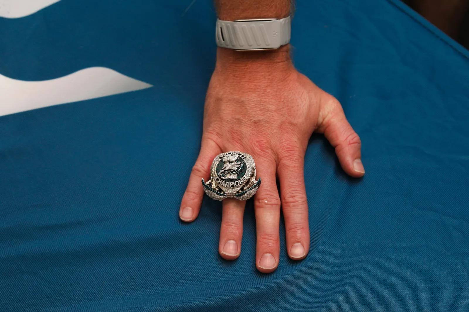 Championship ring worn on a hand resting on a team flag